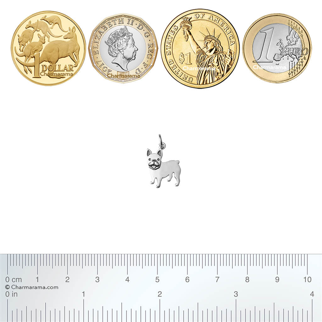 Sterling silver French bulldog charm with coins and ruler for scale on a white background