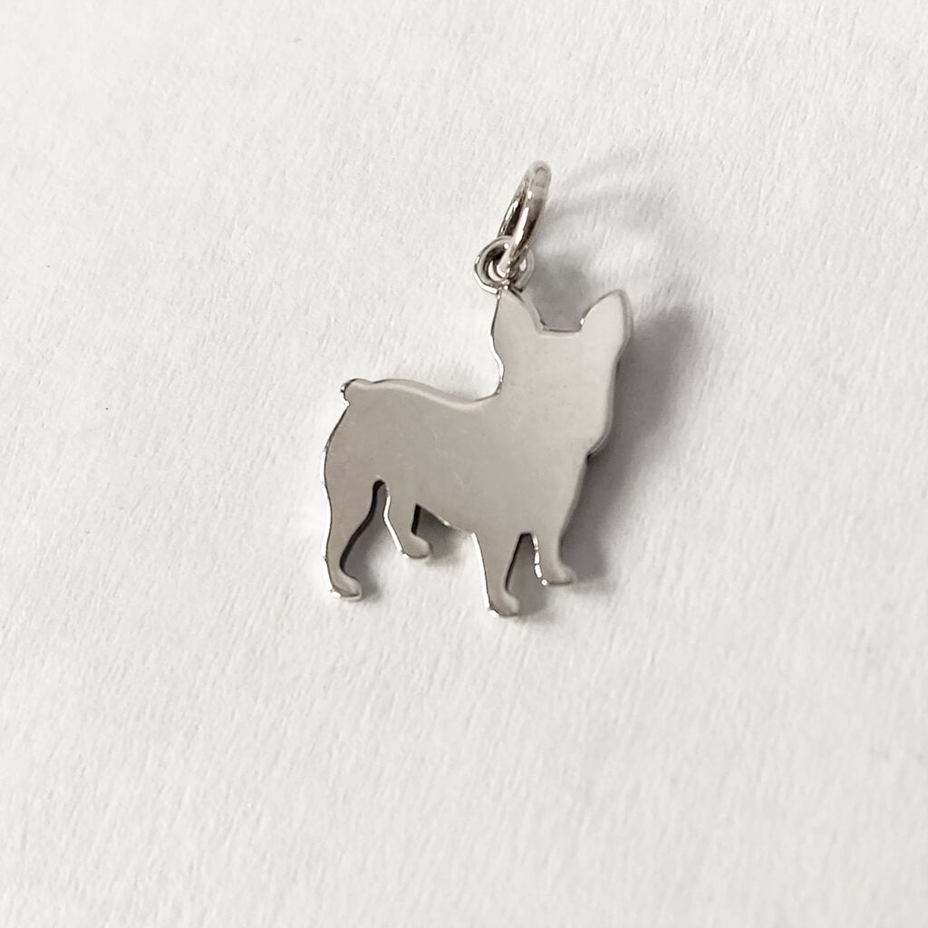 Reverse side of a sterling silver French bulldog charm on a white background