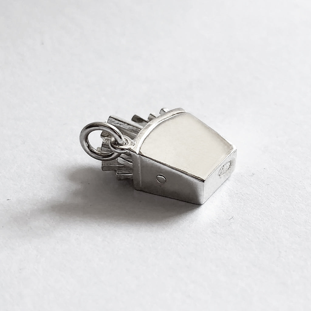 Reverse side of a sterling silver French fries charm on a white background