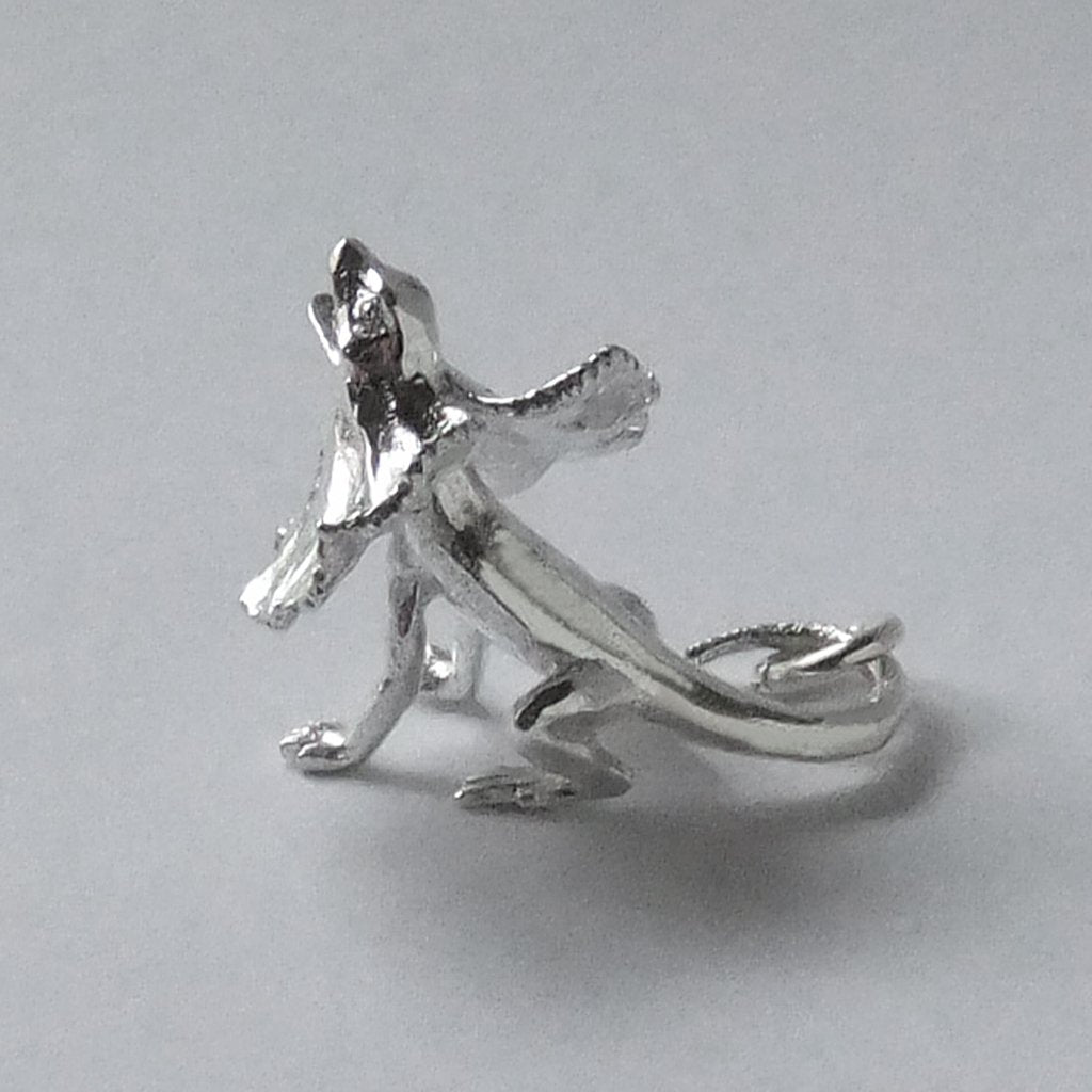 Sterling silver frill necked lizard charm on a grey background