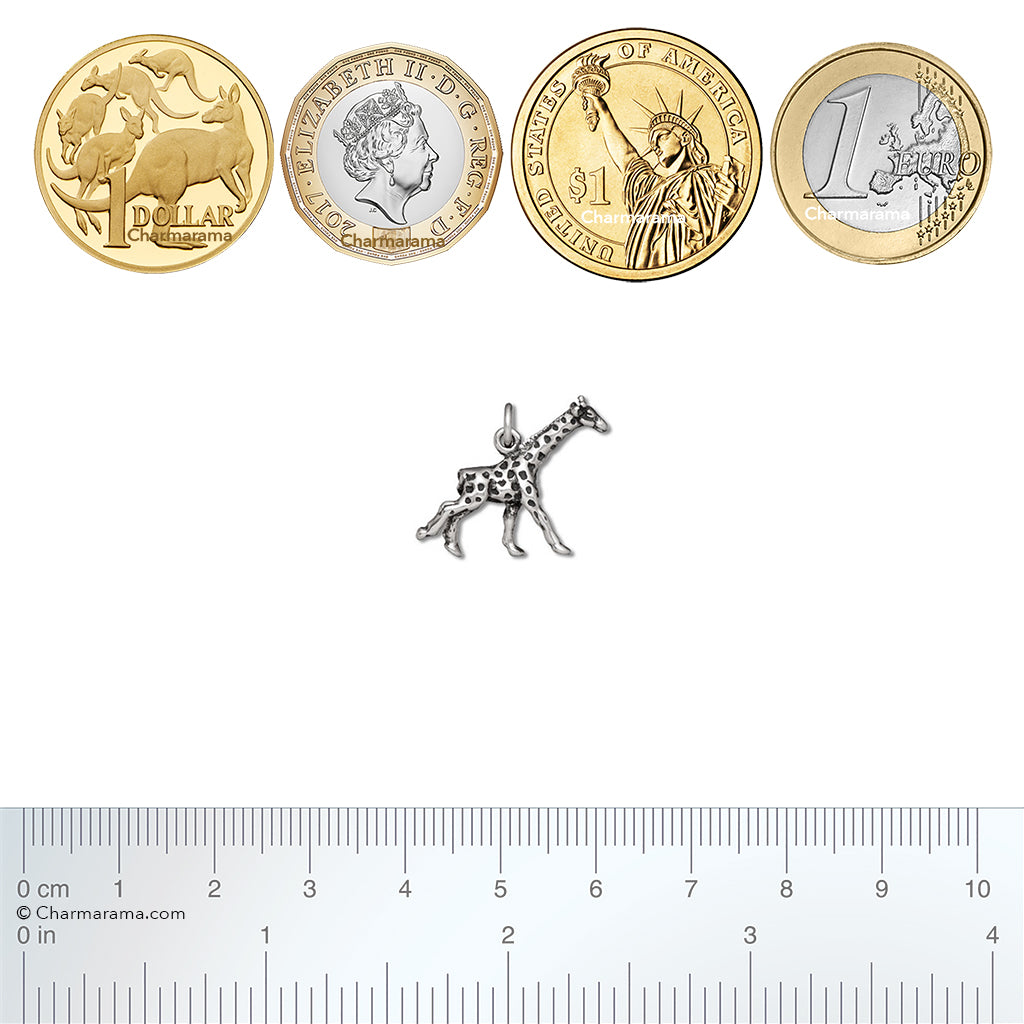 Sterling silver giraffe charm with coins and ruler for scale on a white background