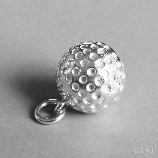 Sterling silver golf ball charm on a grey background