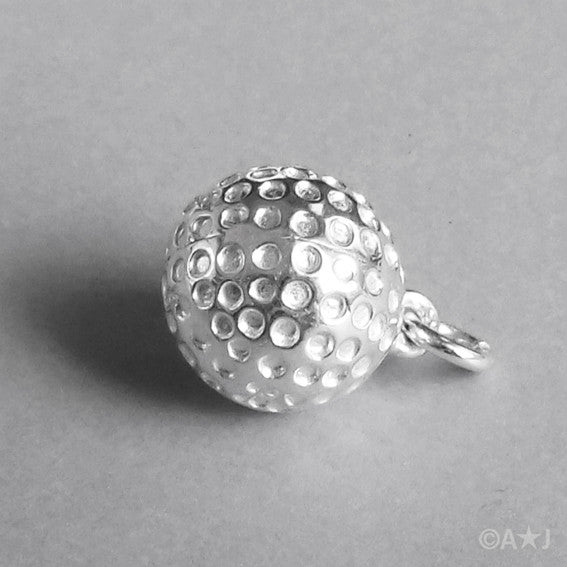 Sterling silver golf ball charm on a grey background