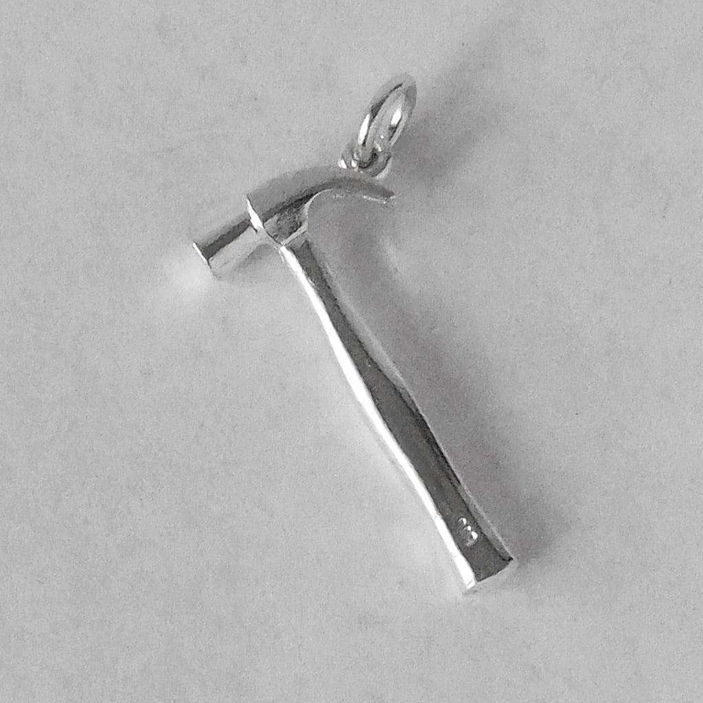 Sterling silver hammer charm on a grey background