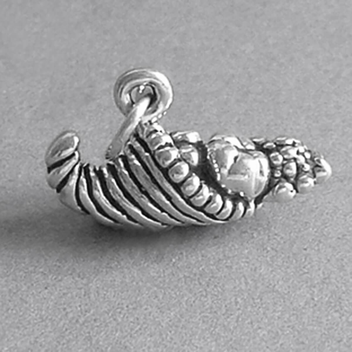 Sterling silver Cornucopia horn or plenty charm on a grey background