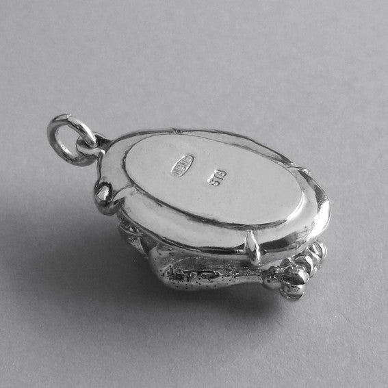 Underside of sterling silver roast turkey charm on a grey background