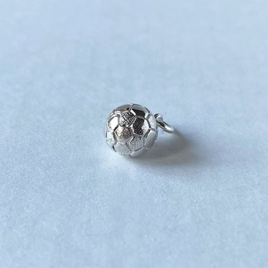 Sterling silver football charm on a grey background