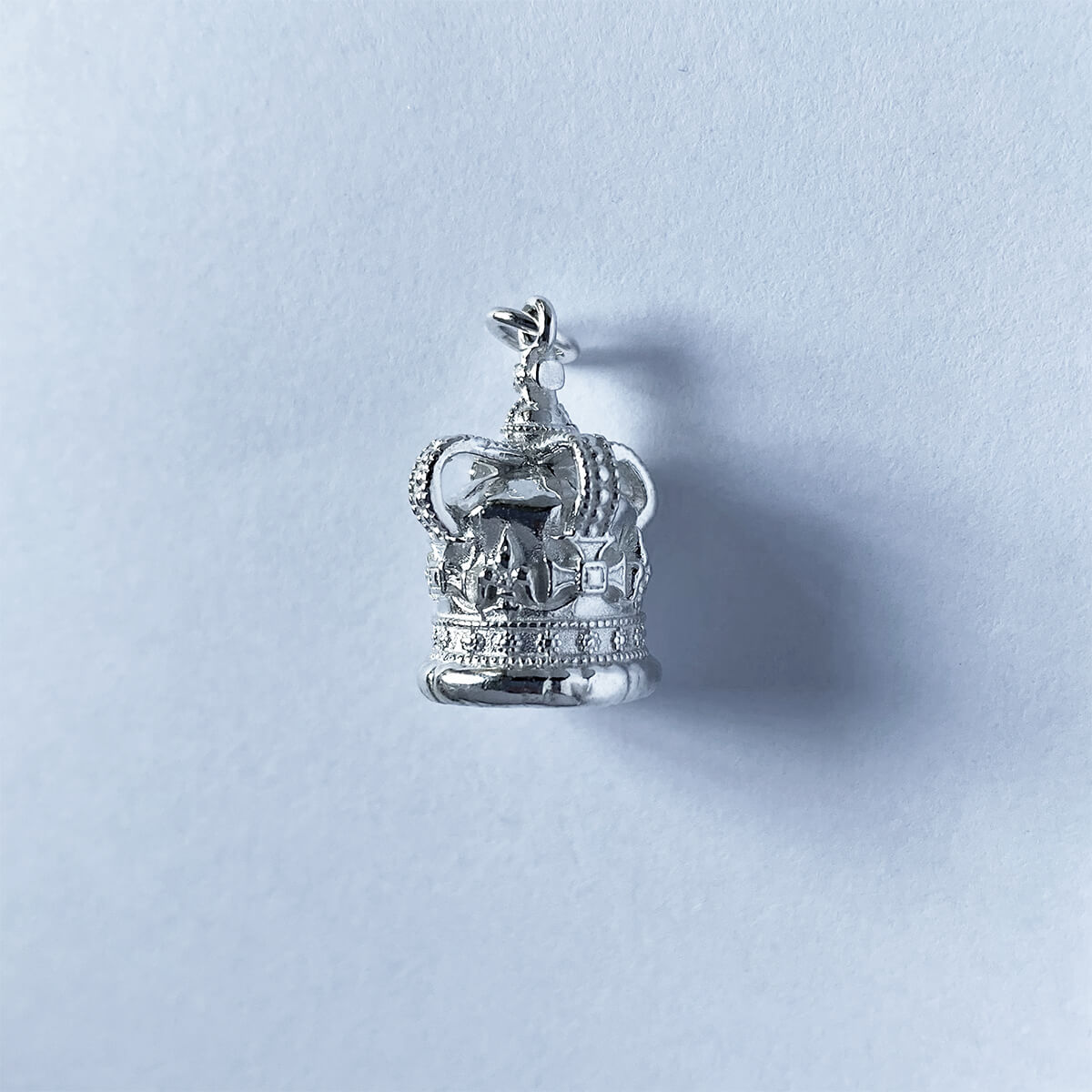 Sterling silver St Edward's crown charm on a light grey background
