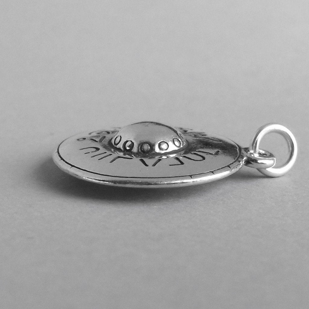 Sterling silver flying saucer charm on a grey background