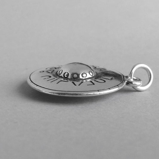 Sterling silver flying saucer charm on a grey background