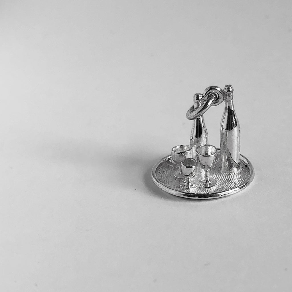 Sterling silver wine bottles and glasses on drinks tray charm on a grey background
