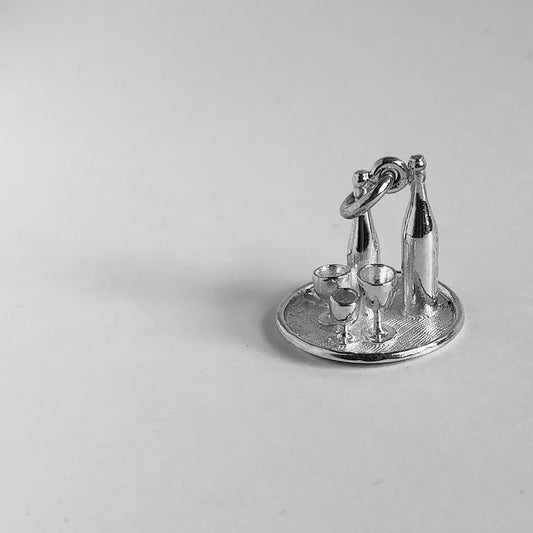 Sterling silver wine bottles and glasses on drinks tray charm on a grey background