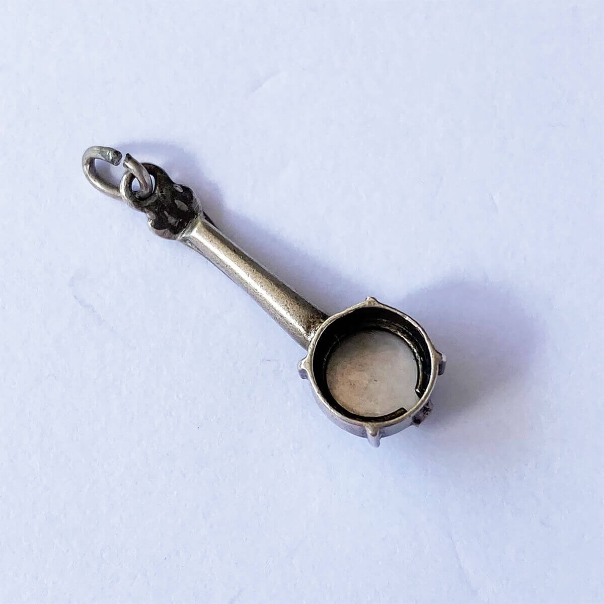 Silver vintage banjo charm on grey background