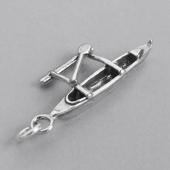 canoe and outrigger charm on grey background
