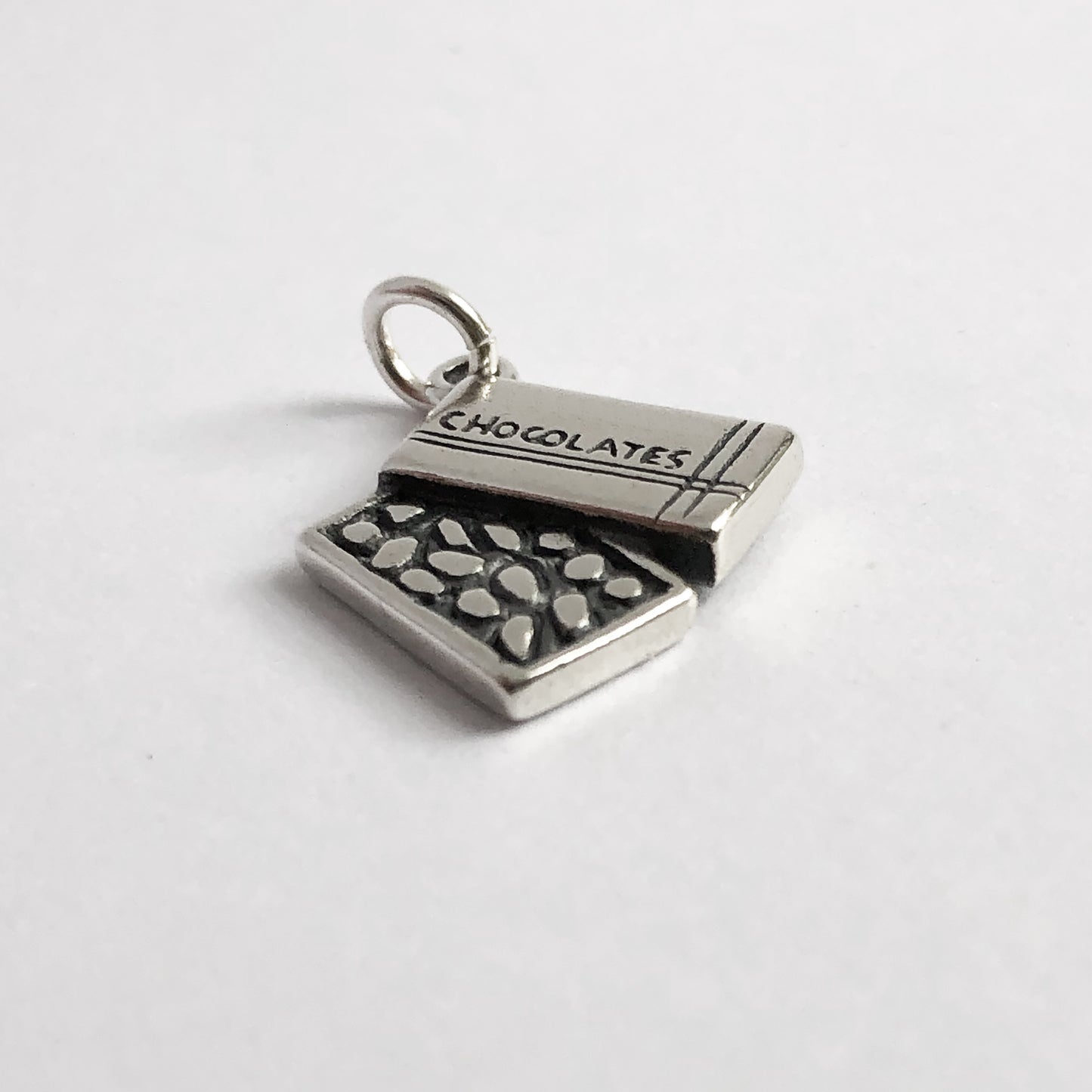 silver box of chocolates charm on light grey background