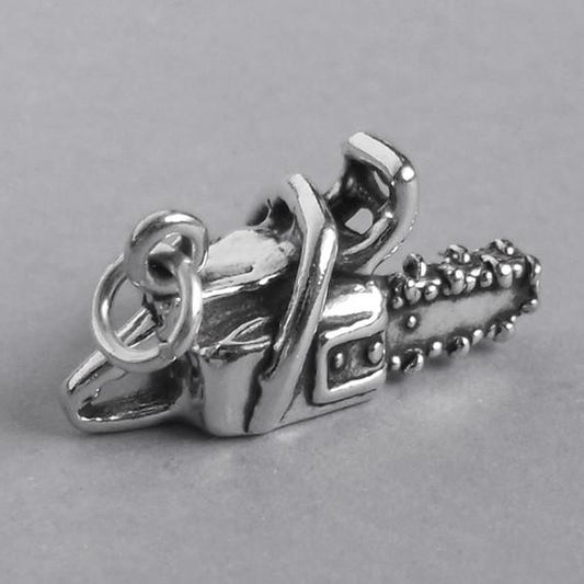 silver chainsaw charm pendant on a grey background