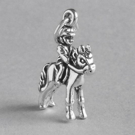 silver child on pony charm on grey background