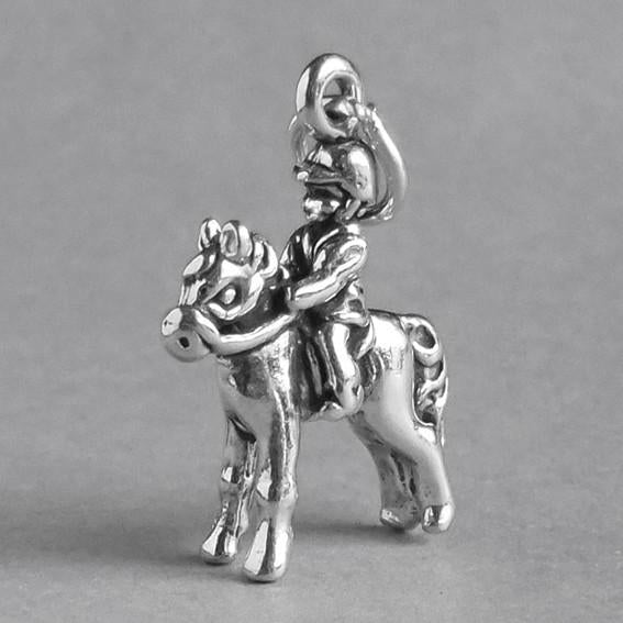 silver child on pony charm on grey background