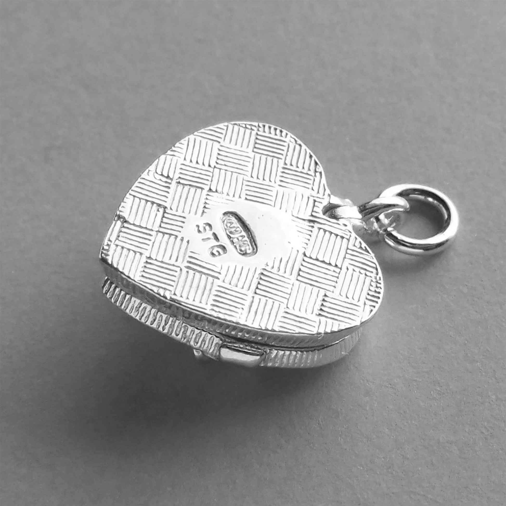 back of silver heart shaped chocolate box charm on a grey background