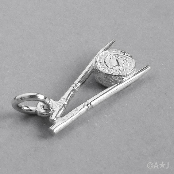 silver chopsticks and sushi charm on grey background