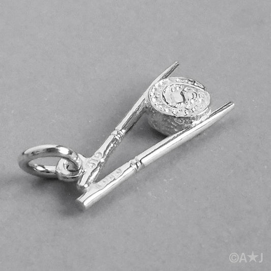 silver chopsticks and sushi charm on grey background