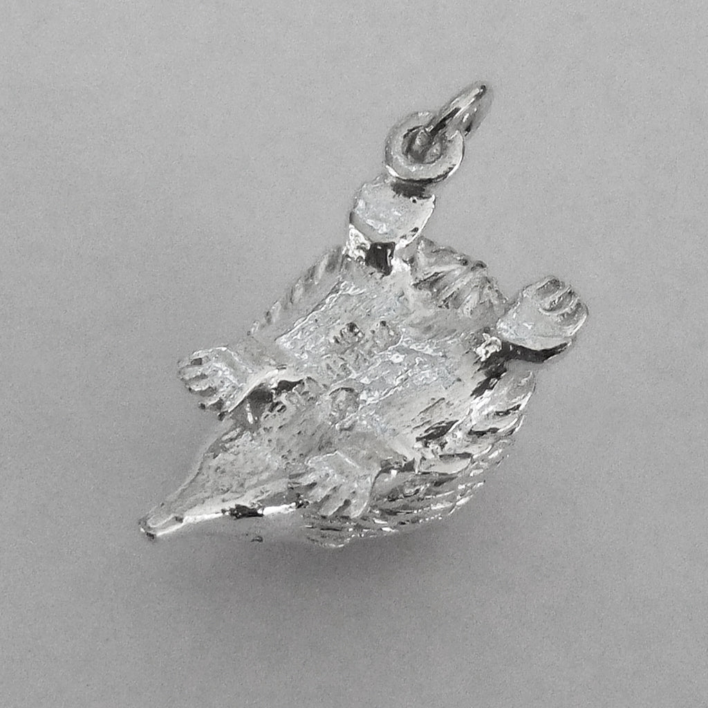 Underside of a sterling silver Australian echidna charm on a grey background