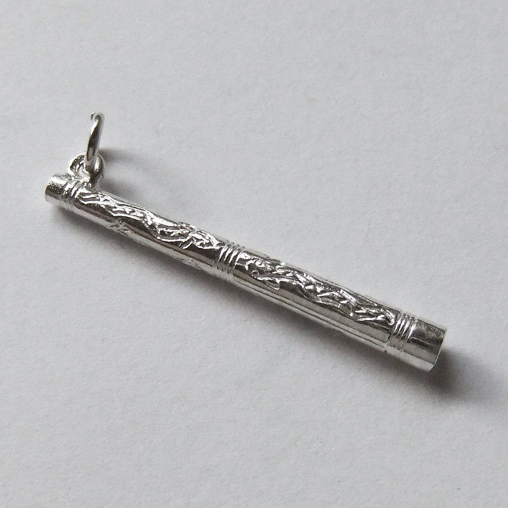 Sterling silver Didgeridoo charm on a grey background