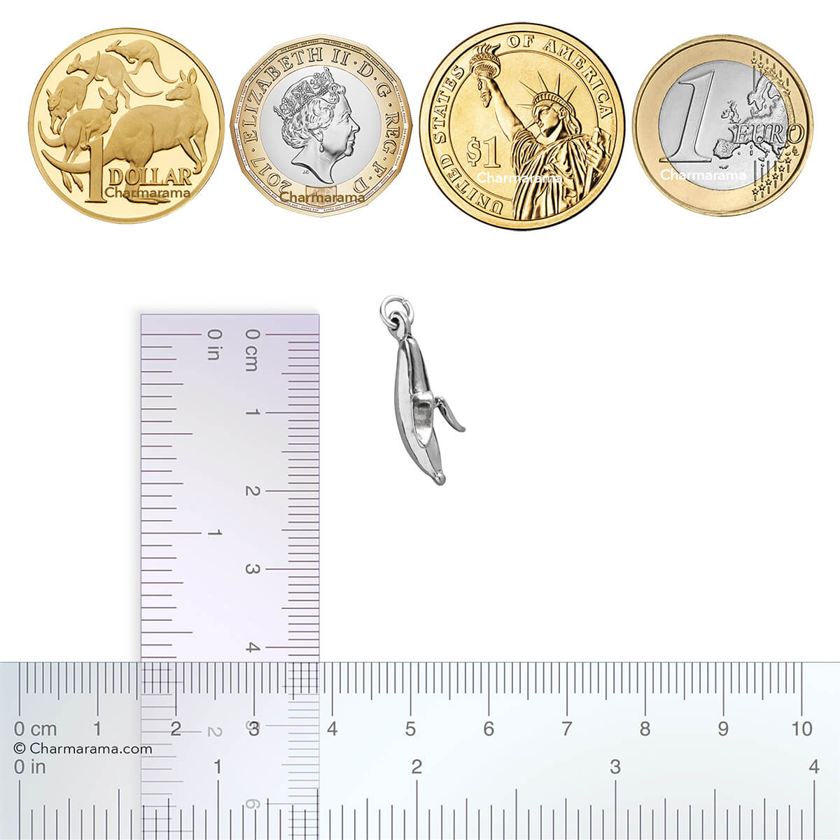 A silver banana charm with coins and ruler for scale.