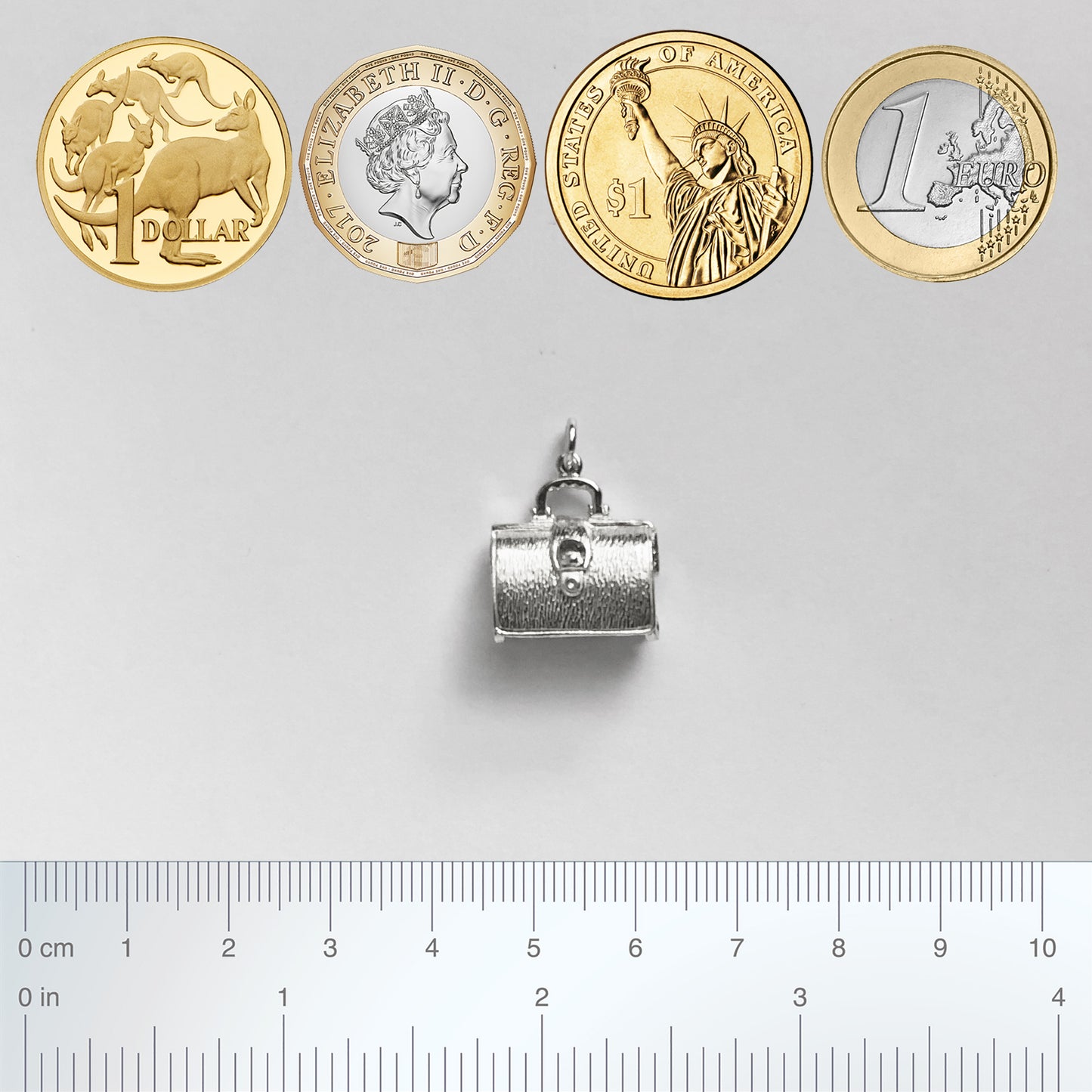 Sterling silver briefcase charm which opens to lingerie on a white background with coins and ruler for scale