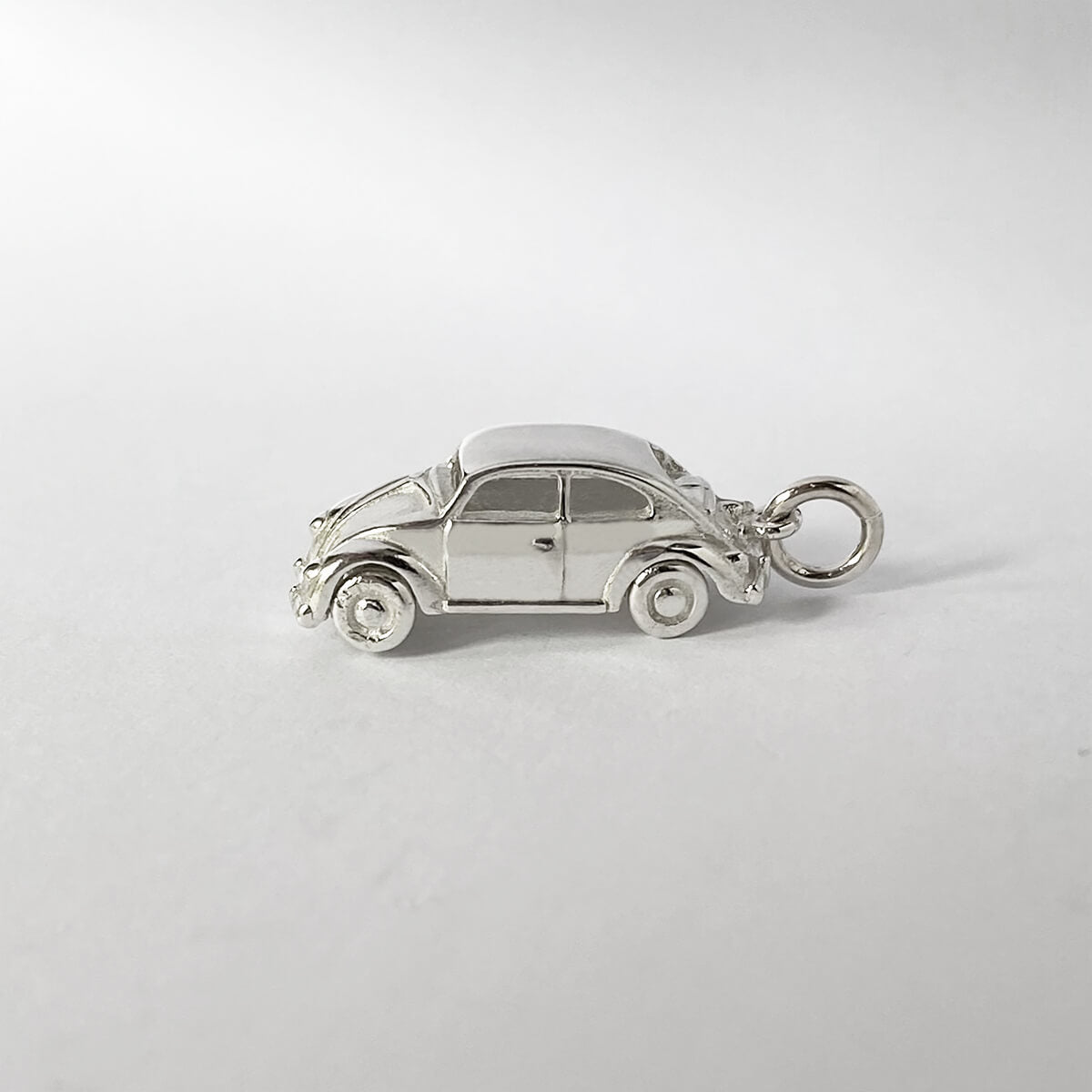 sterling silver beetle car pendant on grey background