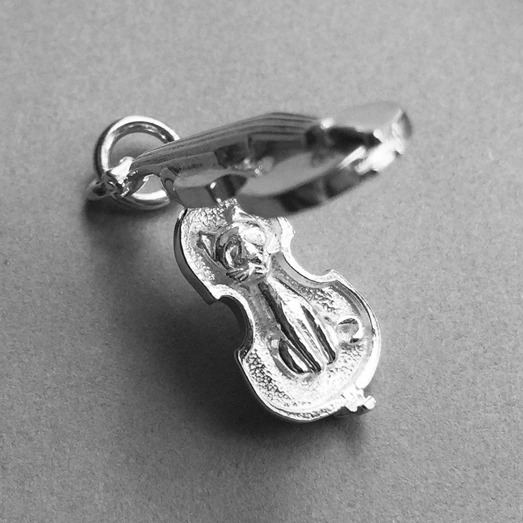 silver violin charm open to cat on a grey background