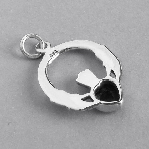 back of sterling silver claddagh charm on grey background