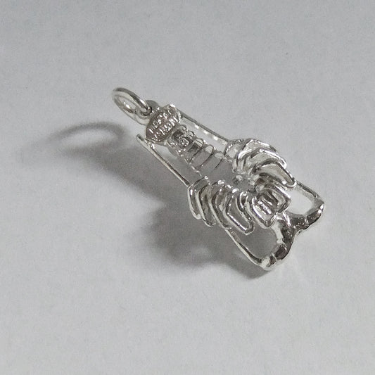 underside of a sterling silver crayfish charm on light grey background