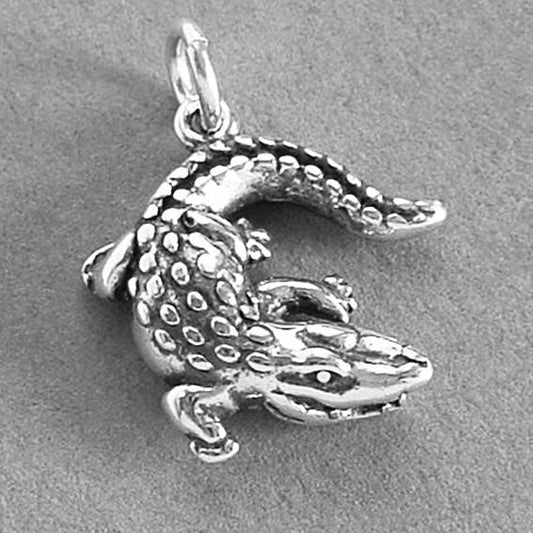 silver crocodile charm on grey background