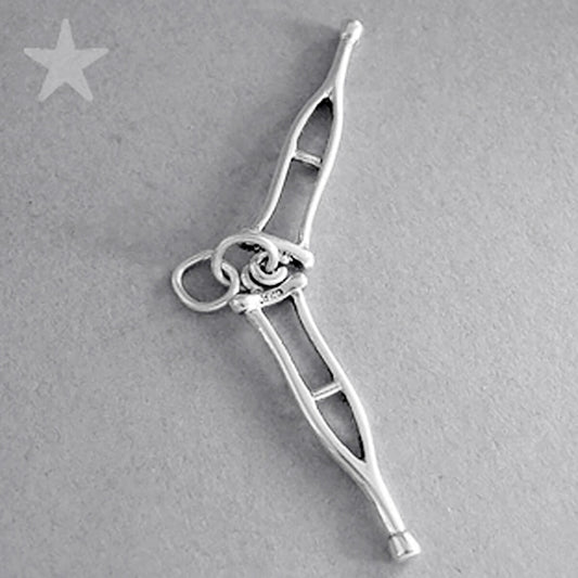 Sterling silver crutches charm on a grey background
