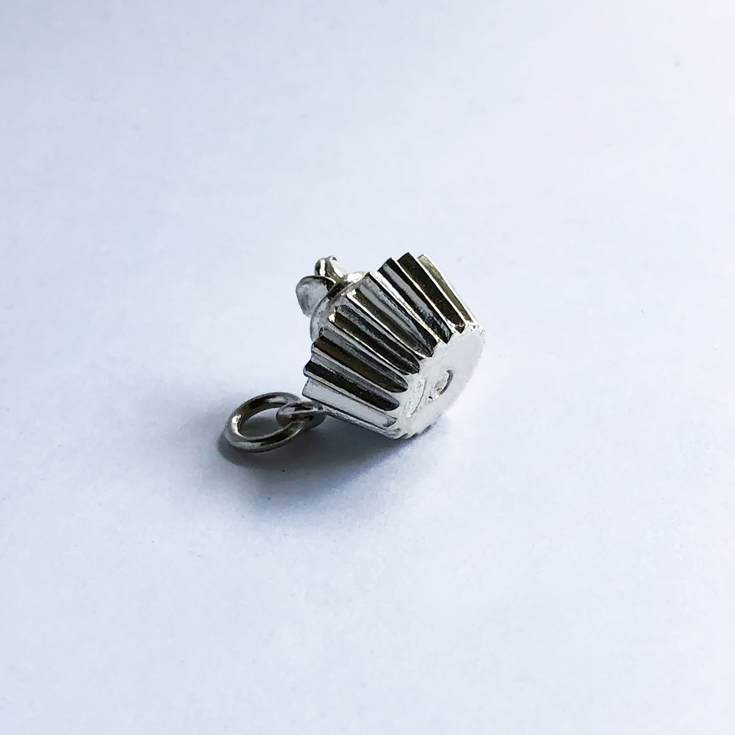 Underside of a sterling silver cupcake charm on a white background