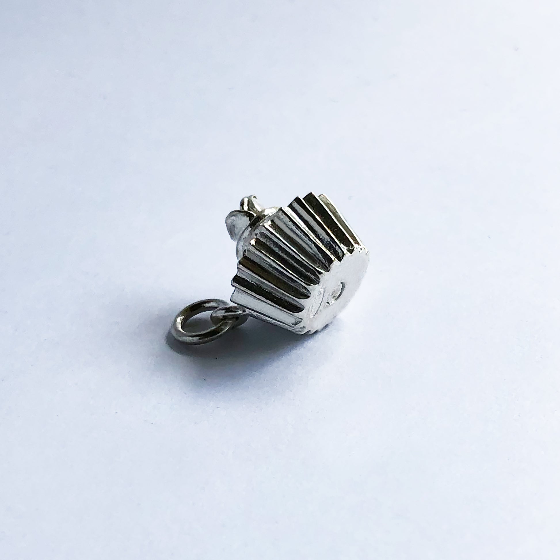 Underside of a sterling silver cupcake charm on a white background