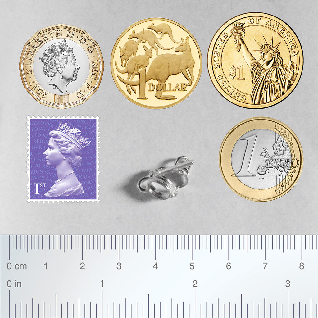 Sterling silver diving mask charm with coins, ruler and postage stamp for scale on a white background