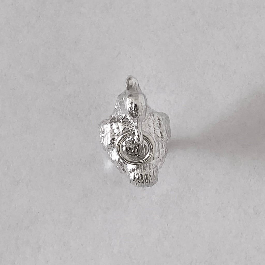 Sterling silver dodo charm viewed from above on a grey background