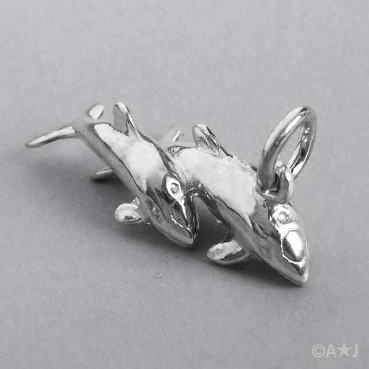 Sterling silver dolphins charm on a grey background