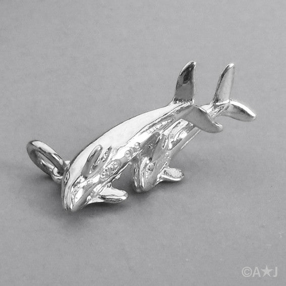 Sterling silver dolphins charm on a grey background