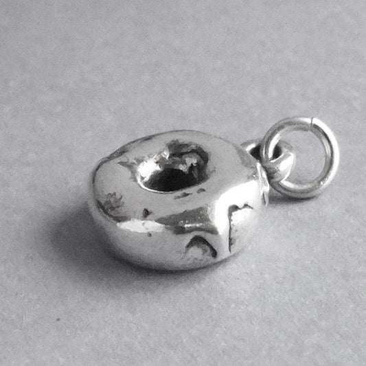 Sterling silver donut charm on a grey background