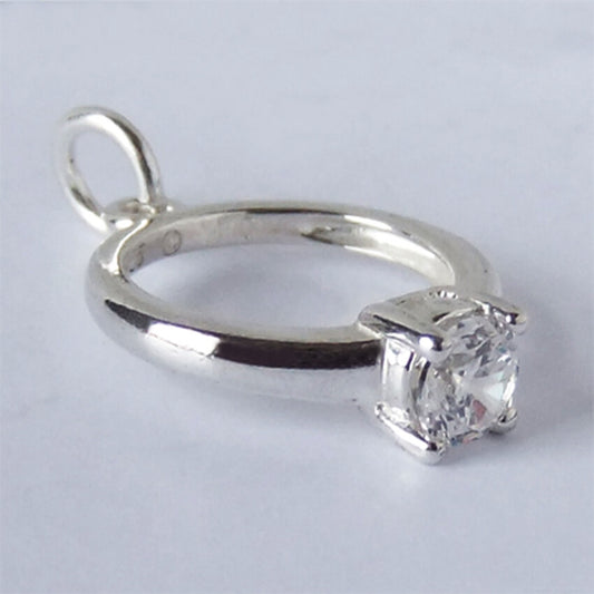 silver and crystal engagement ring charm on light grey background