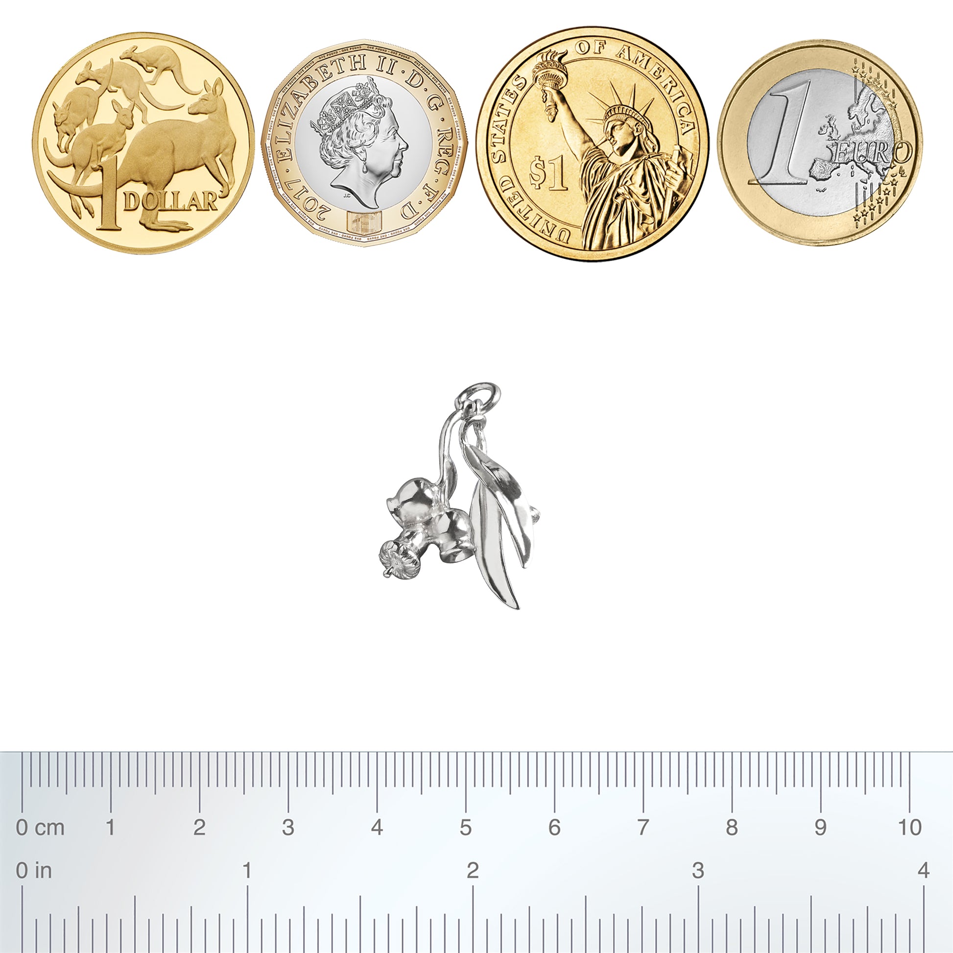 Sterling silver eucalyptus charm with coins and ruler for scale on a white background