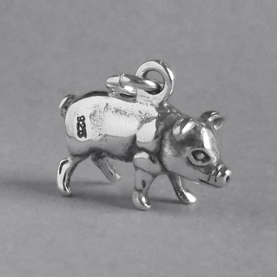 silver pig charm on grey background