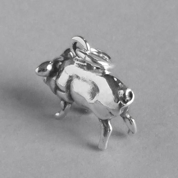 silver pig charm viewed from back on grey background