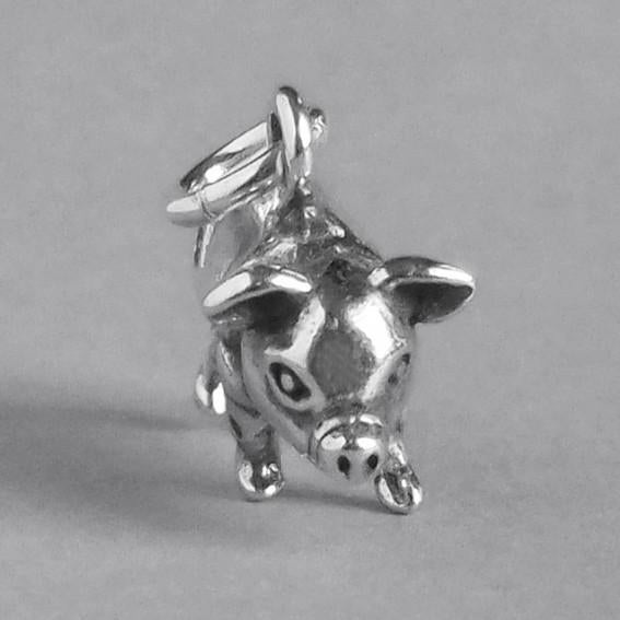 silver pig charm on grey background