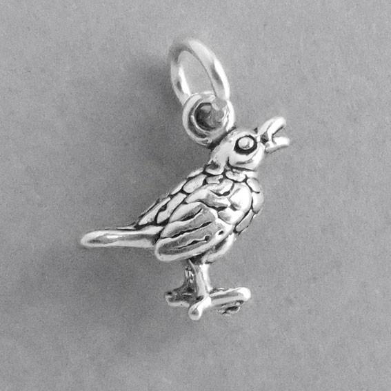 silver song bird charm on a grey background