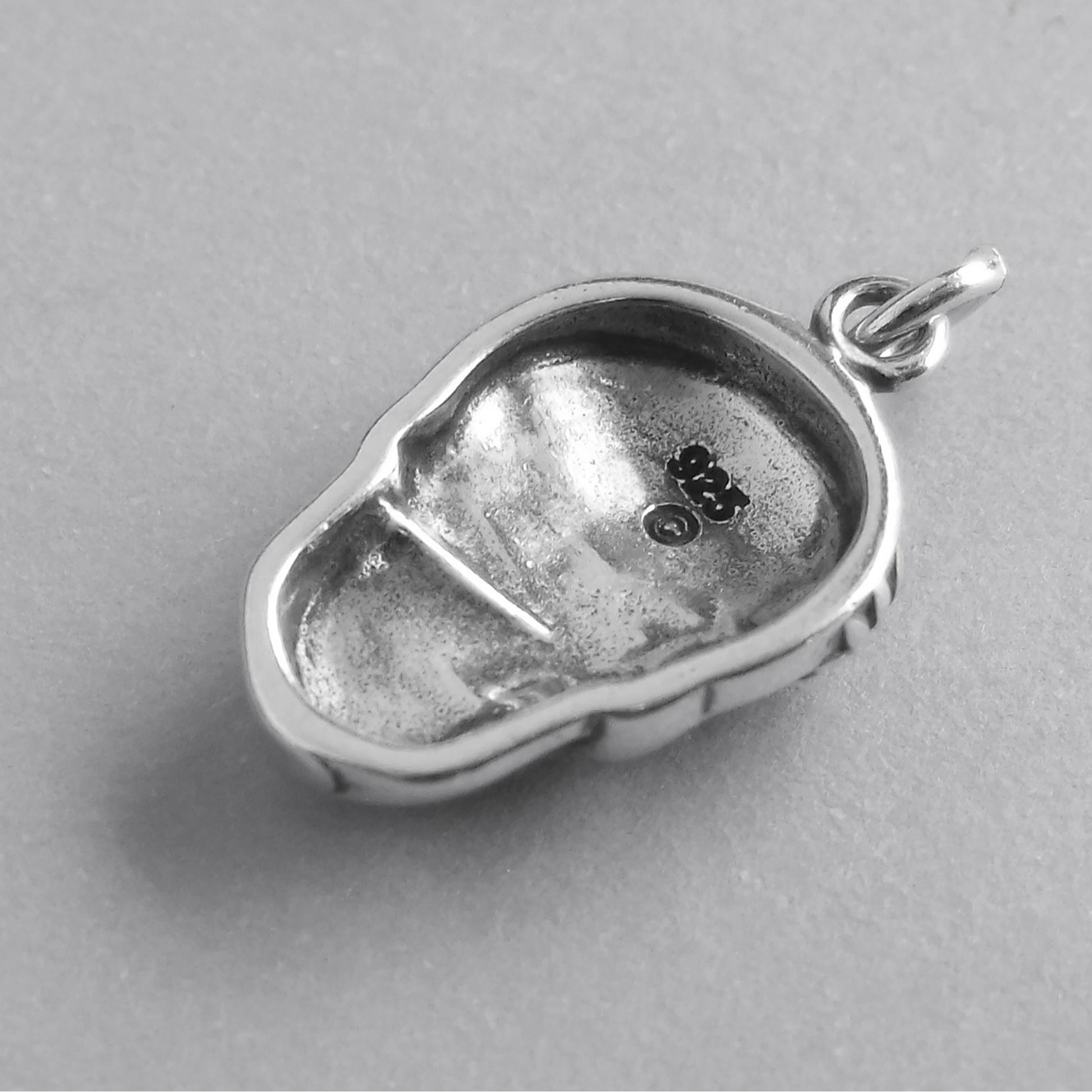 back of silver sugar skull charm on grey background