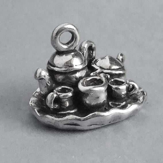 silver tea set charm on grey background